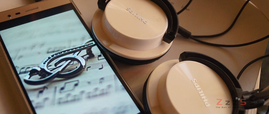 2 Comparisons Between Gambling Historians and Music Critics mobile phone with gclef wallpaper with headset on side - 2 Comparisons Between Gambling Historians and Music Critics